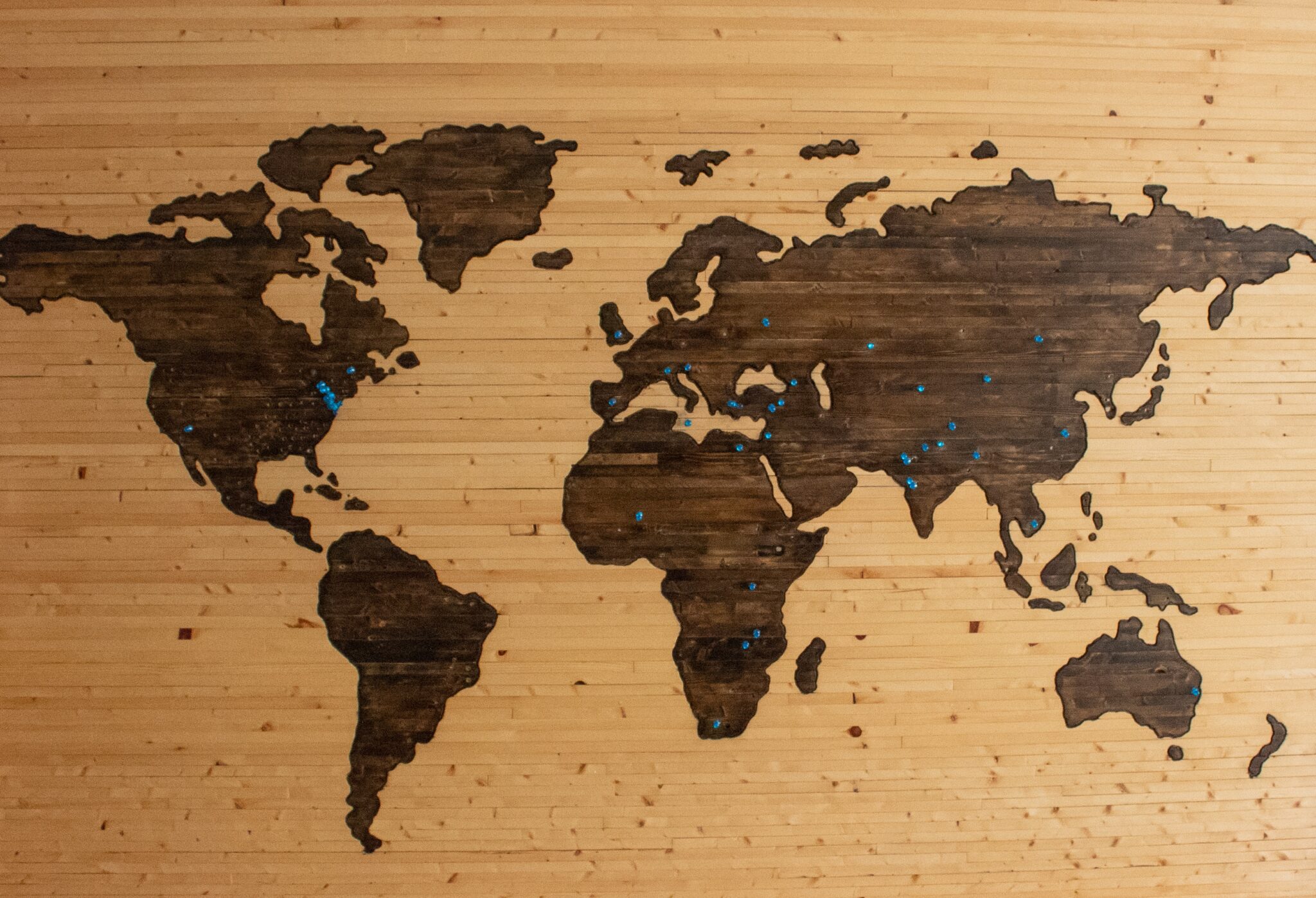 wooden world map with pins in it